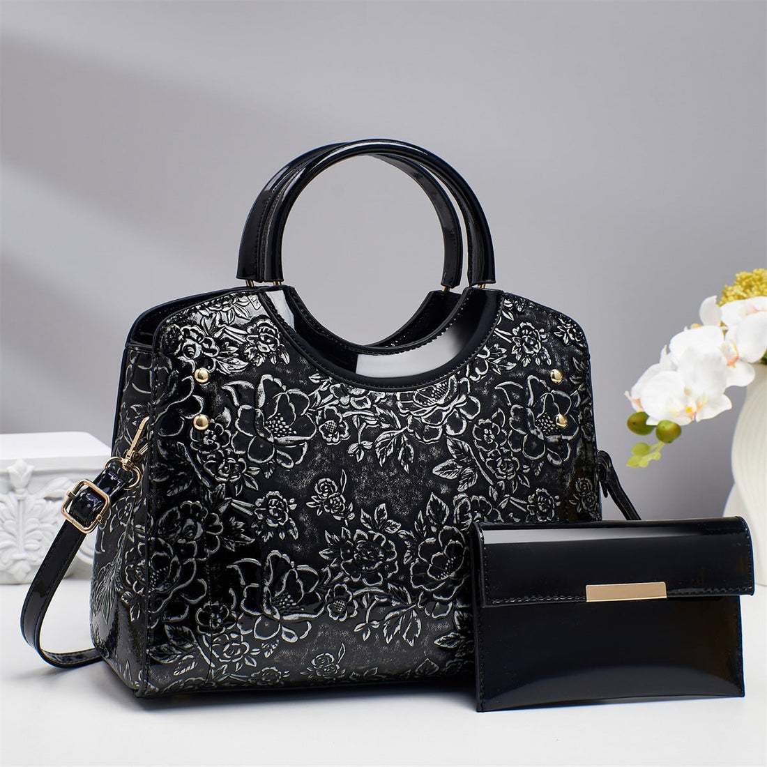 Black floral-embossed structured tote bag set with matching pouch