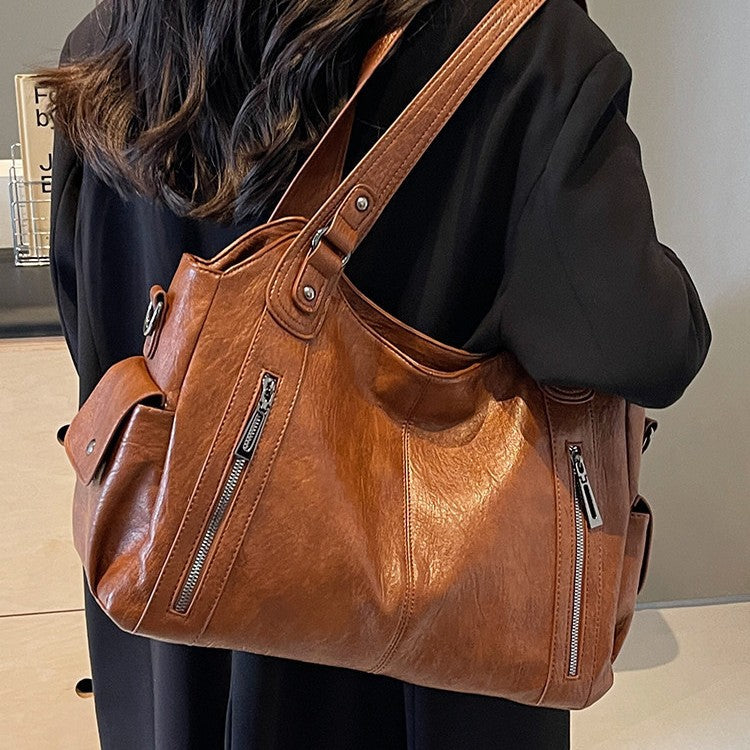 Brown vintage crossbody tote bag shown in a shoulder carry view